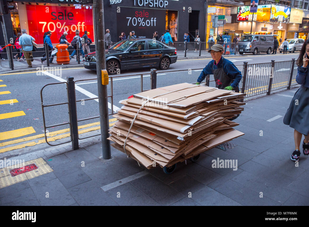 L'uomo spingendo pila di scatole di cartone per il riciclaggio, Hong Kong Foto Stock