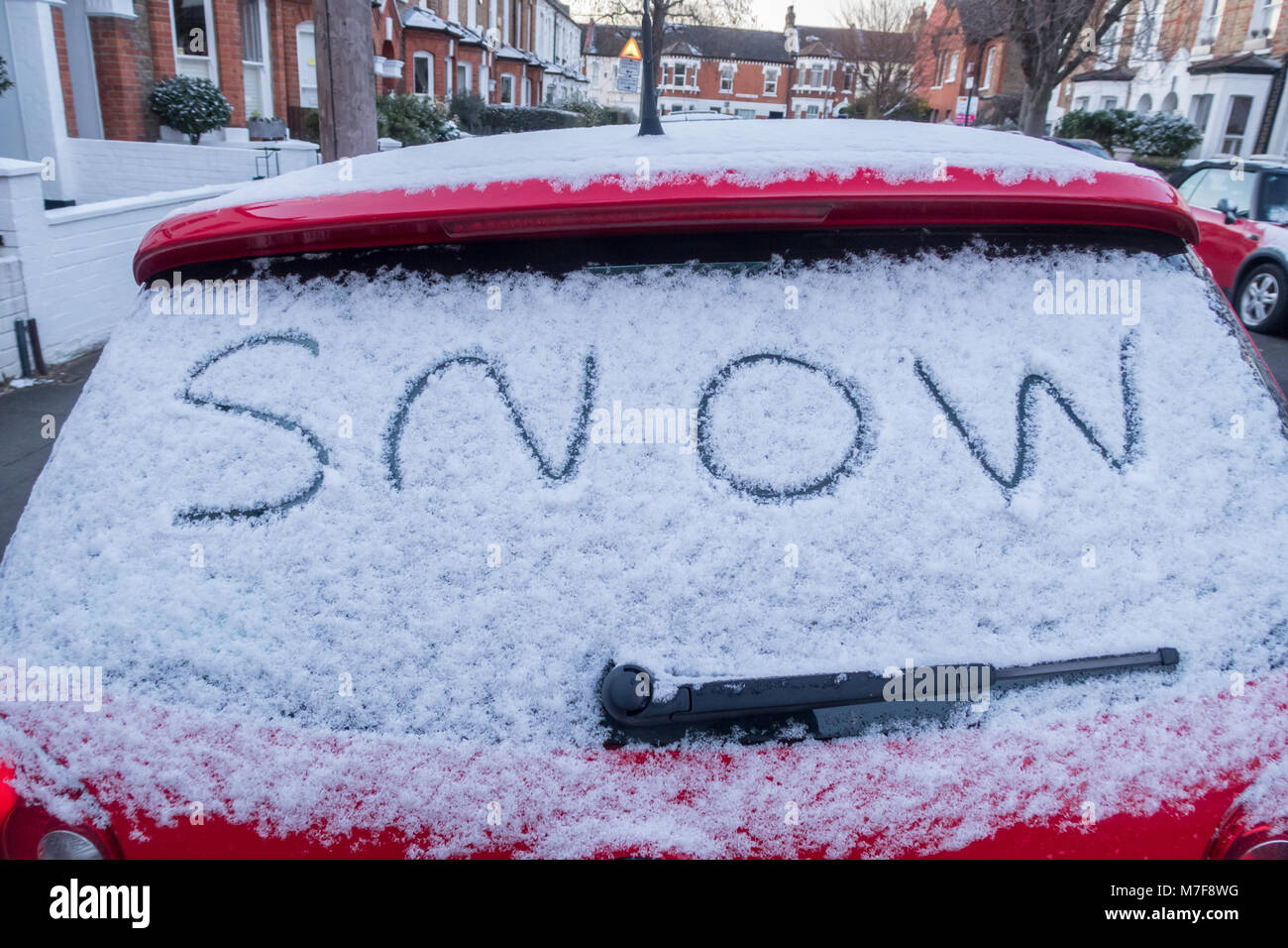 La parola scritta di neve sul lunotto posteriore di una coperta di neve auto. Foto Stock La parola scritta di neve sul lunotto posteriore di una coperta di neve auto. Foto Stock