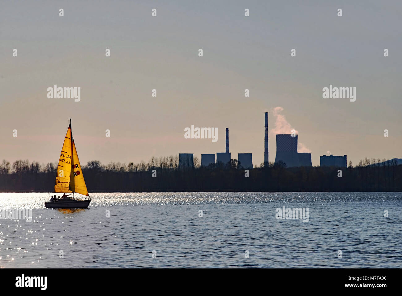 Giallo in barca a vela sul lago e sullo sfondo la elettori con comignoli fumanti Foto Stock