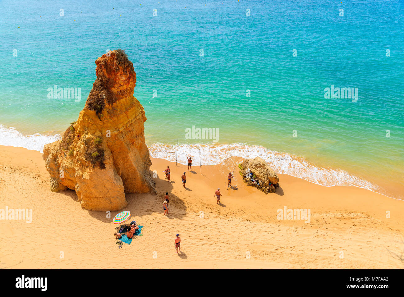 Costa Algarve, Portogallo - 14 Maggio 2015: turisti la pesca su Praia da rocha beach con colore dorato rocce nella città di Portimao, Portogallo. Foto Stock