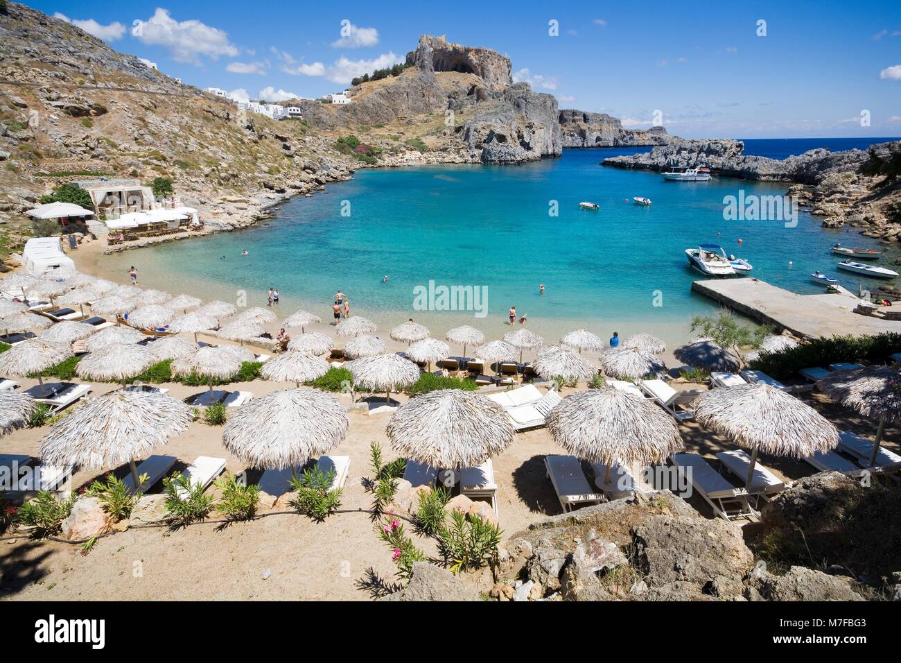 Spiaggia di Saint Paul Bay a Lindos, resti di Acropoli in background, Rodi, Grecia Foto Stock