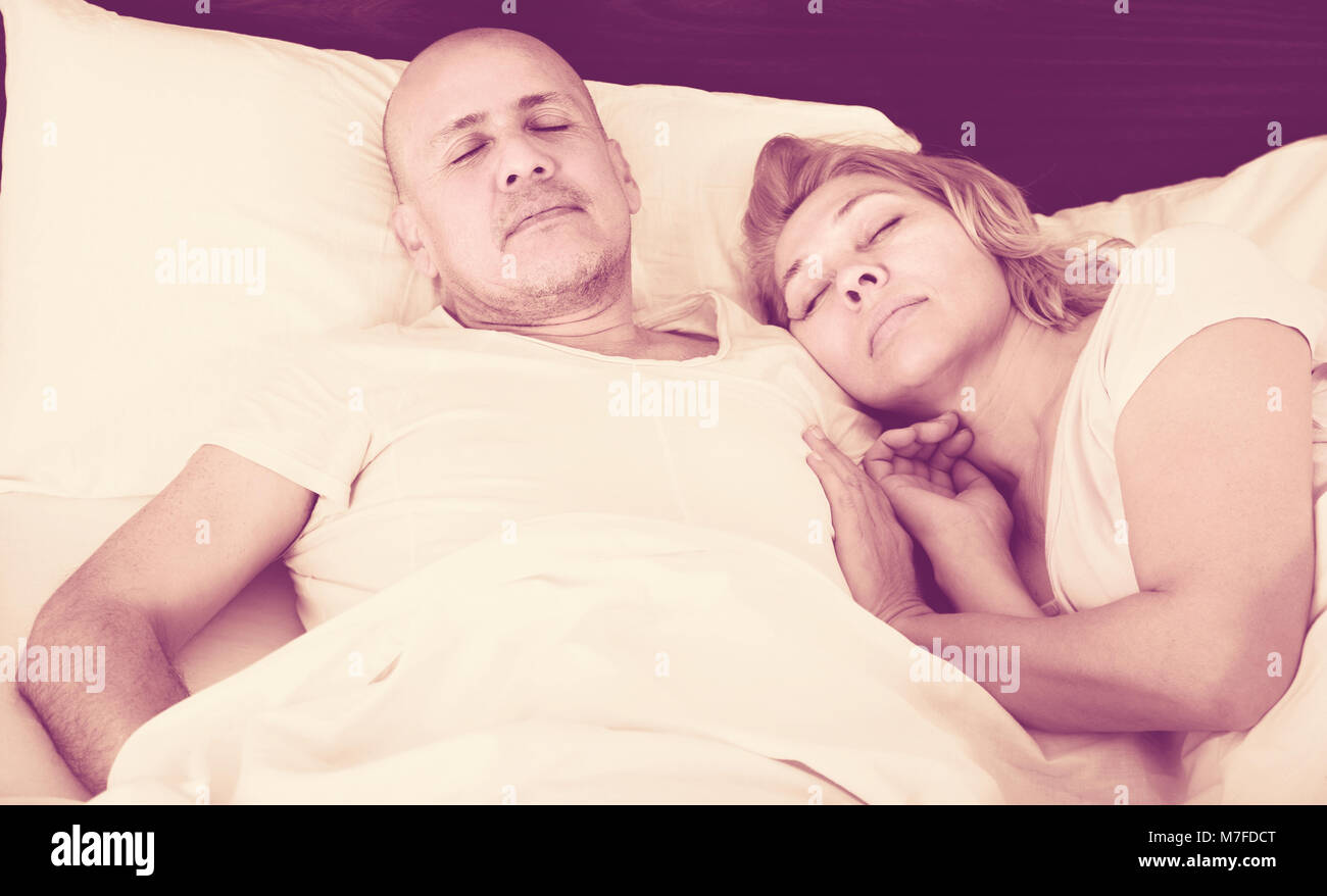 Amorevole famiglia senior di accoppiare a tenuta di dormire nel letto di notte. Focus sull'uomo Foto Stock