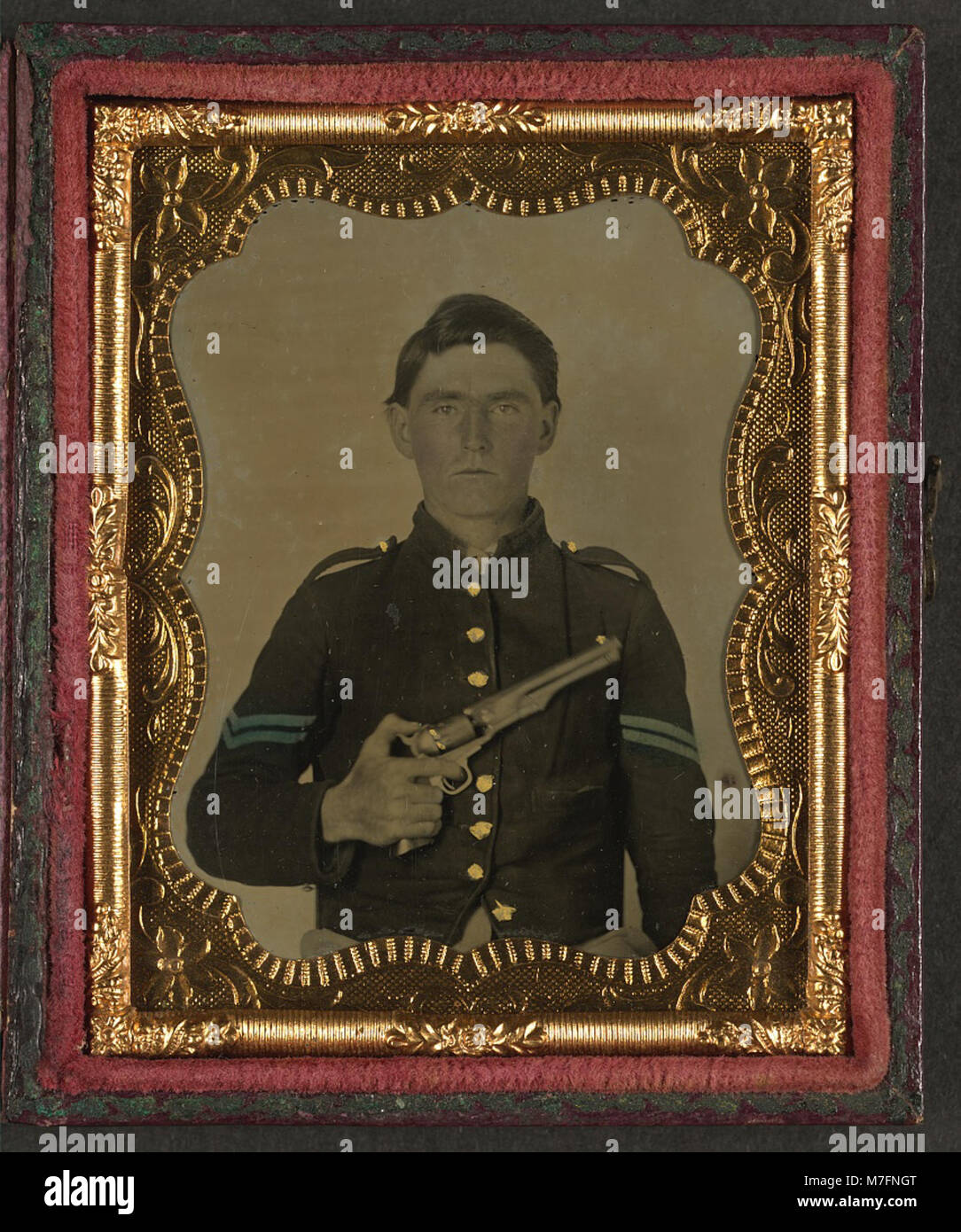 Una fotografia di un soldato unionista non identificato durante la guerra di secessione americana, raffigurata con l'uniforme di un caporale, che tiene un revolver Colt vicino al petto. Foto Stock