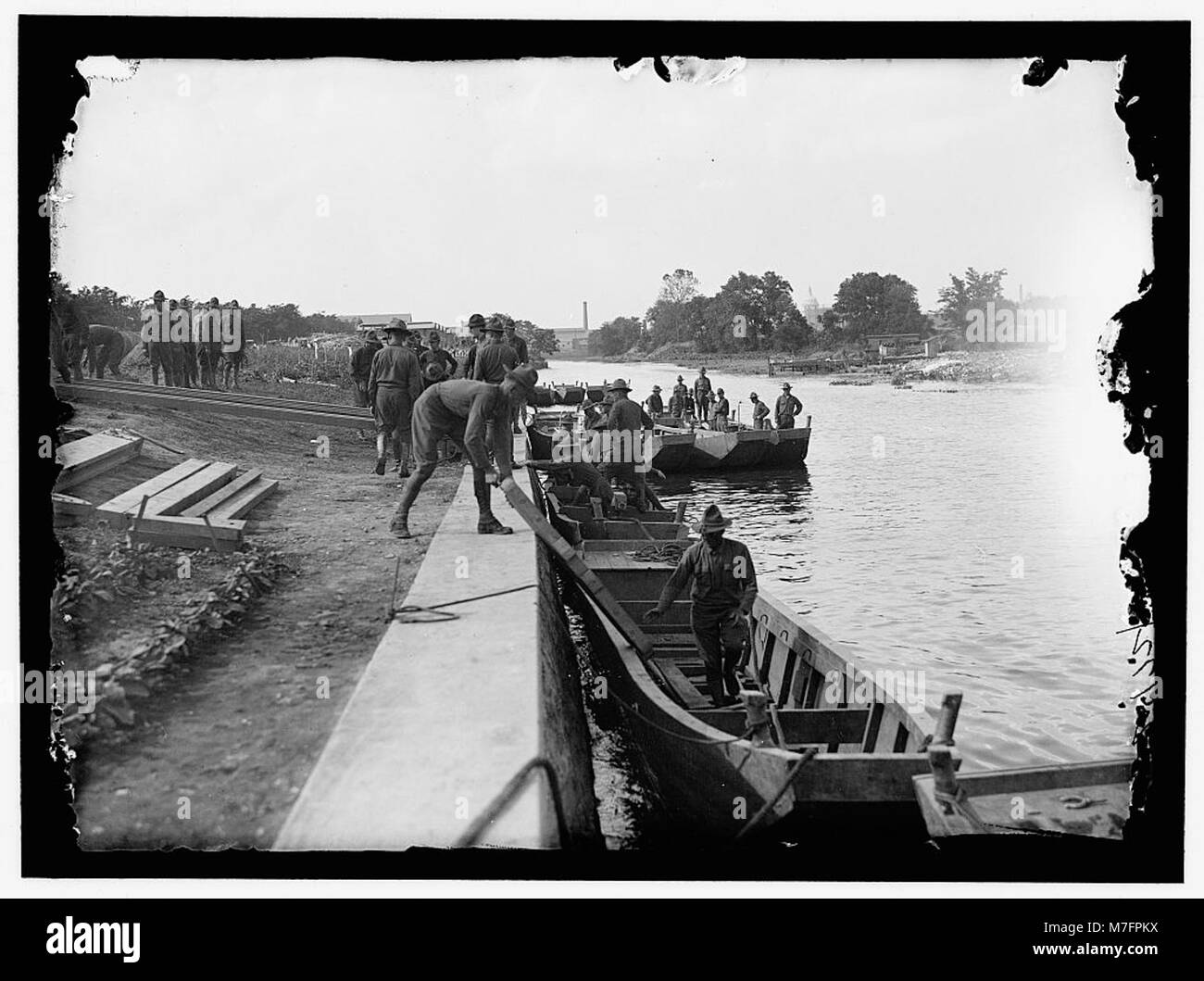 Un'unità ingegneristica dell'esercito americano che costruisce un ponte di pontoni a Washington Barracks, D.C., dimostrando progetti di infrastrutture militari e tecniche di costruzione di ponti. Foto Stock