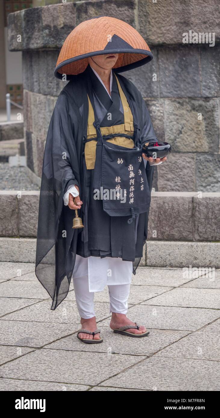 Buddista Giapponese pellegrino testa coperta nel cappello di paglia, bocca  visibile squillando piccola campana in bronzo tenendo un nero laccato vaso  mentre il canto dei sutra Foto stock - Alamy