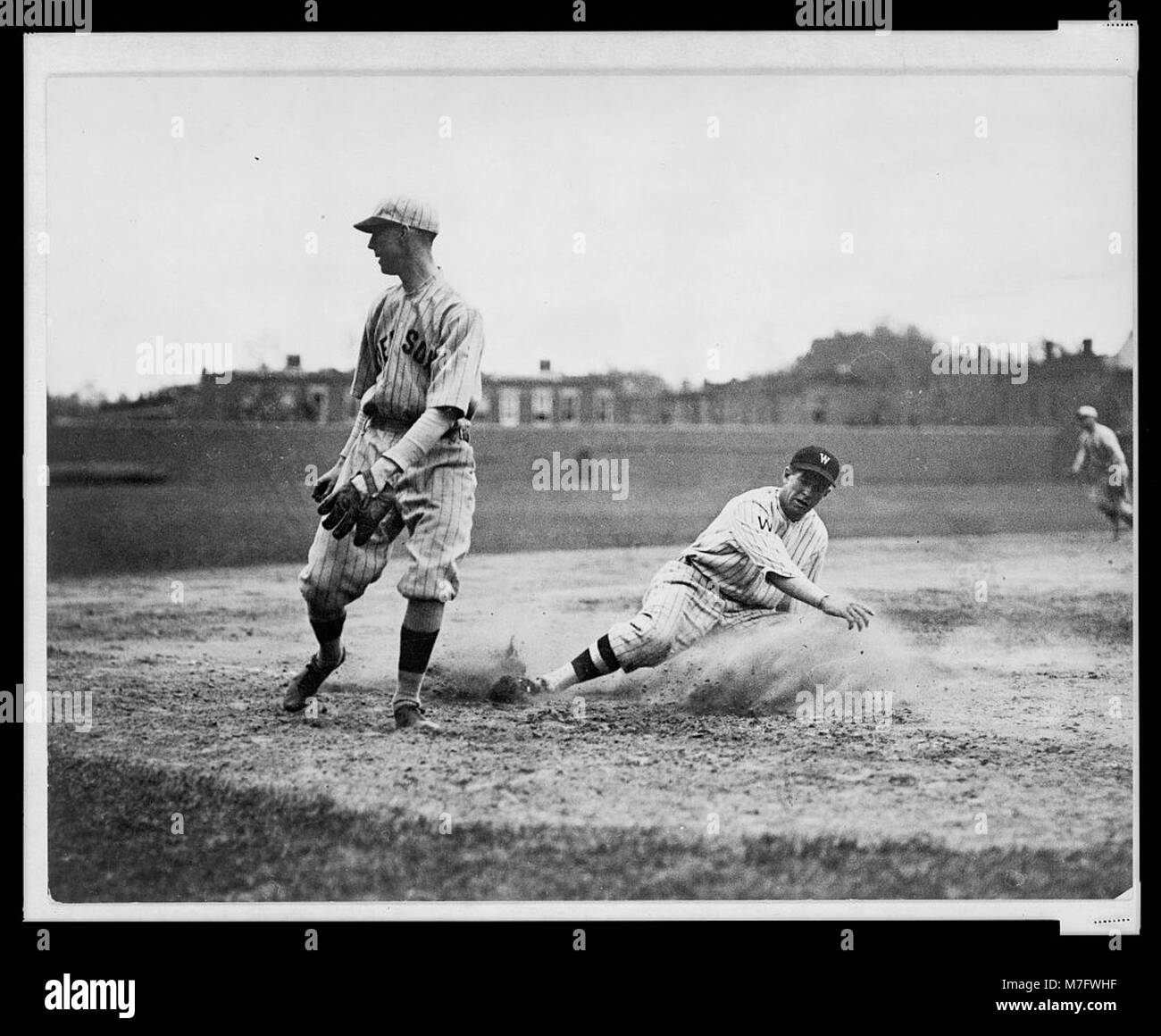 Washington senatori' Bucky Harris scorrevole, come egli riesca a ruba la terza base nel settimo inning di una partita di baseball contro il Boston Red Sox; terzo baseman Joe Dugan orologi il roll ball LCCN2005676974 Foto Stock