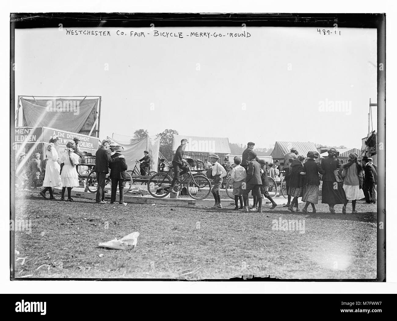Questa fotografia cattura la giostra in bicicletta alla fiera della contea di Westchester a New York, mostrando una popolare giostra di divertimento apprezzata dai visitatori durante i primi anni del XX secolo. Foto Stock