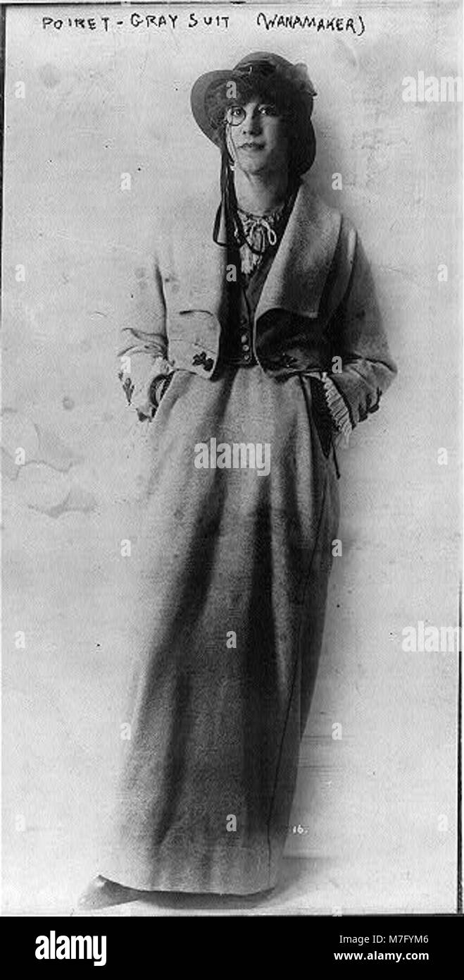 Una donna che indossa una tuta Poiret grigia, fotografata a figura intera nel negozio Wanamaker's. L'immagine mostra la moda dei primi anni del XX secolo e lo stile distintivo di Poiret nell'abbigliamento femminile. Foto Stock