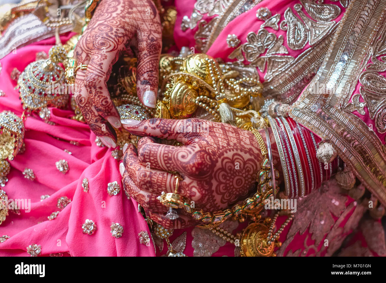 Gioielleria nuziale e henné decorate mani di Indiano sposa Sikh sul giorno di nozze Foto Stock