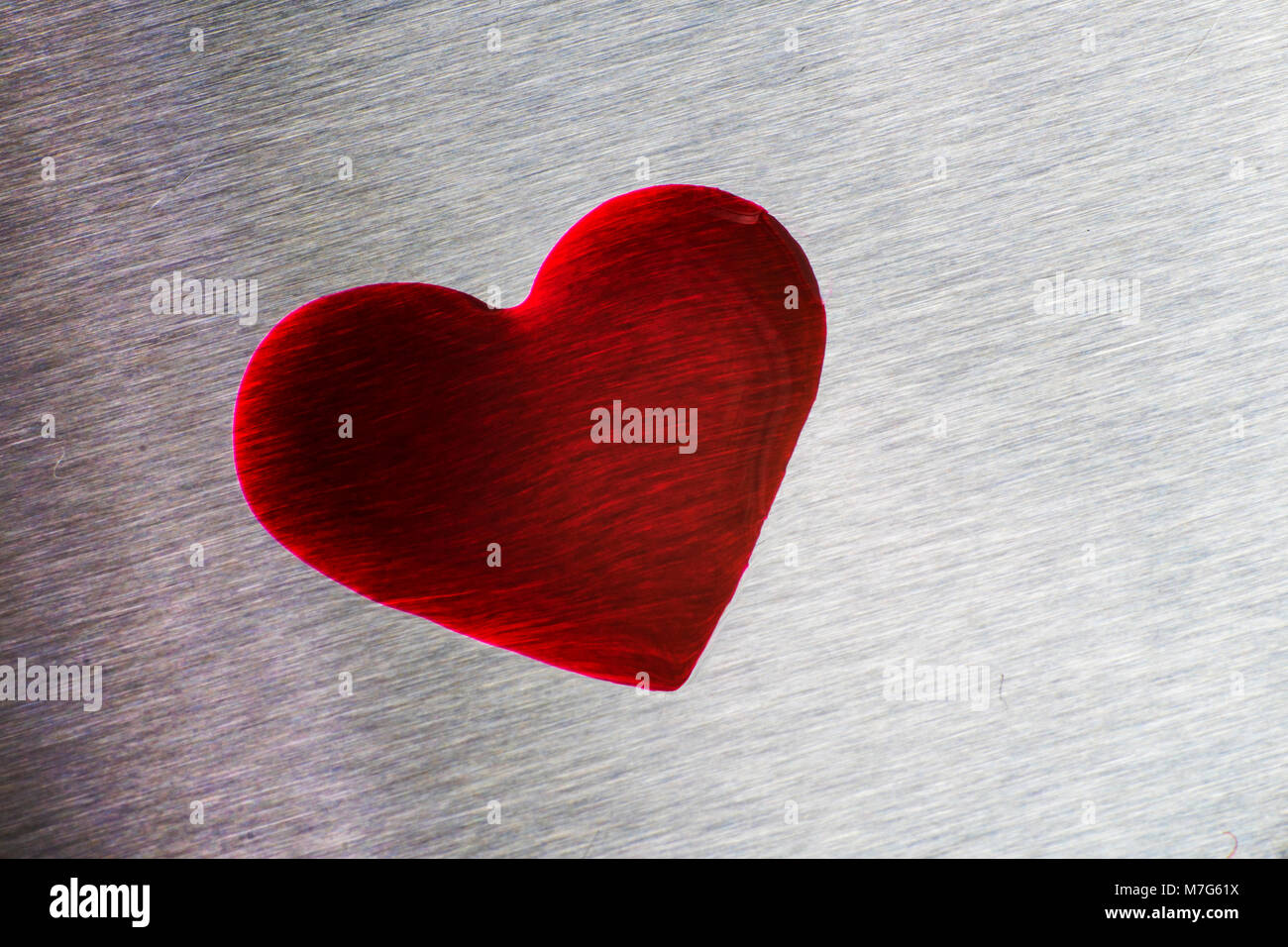 Gocce di colore rosso a forma di cuore. Blu metallizzato di superficie, il giorno di San Valentino Foto Stock