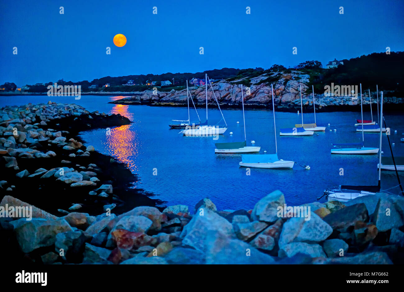 Piena Harvest Moon di notte con un incremento di oltre il porto al Rockport, MA. Foto Stock