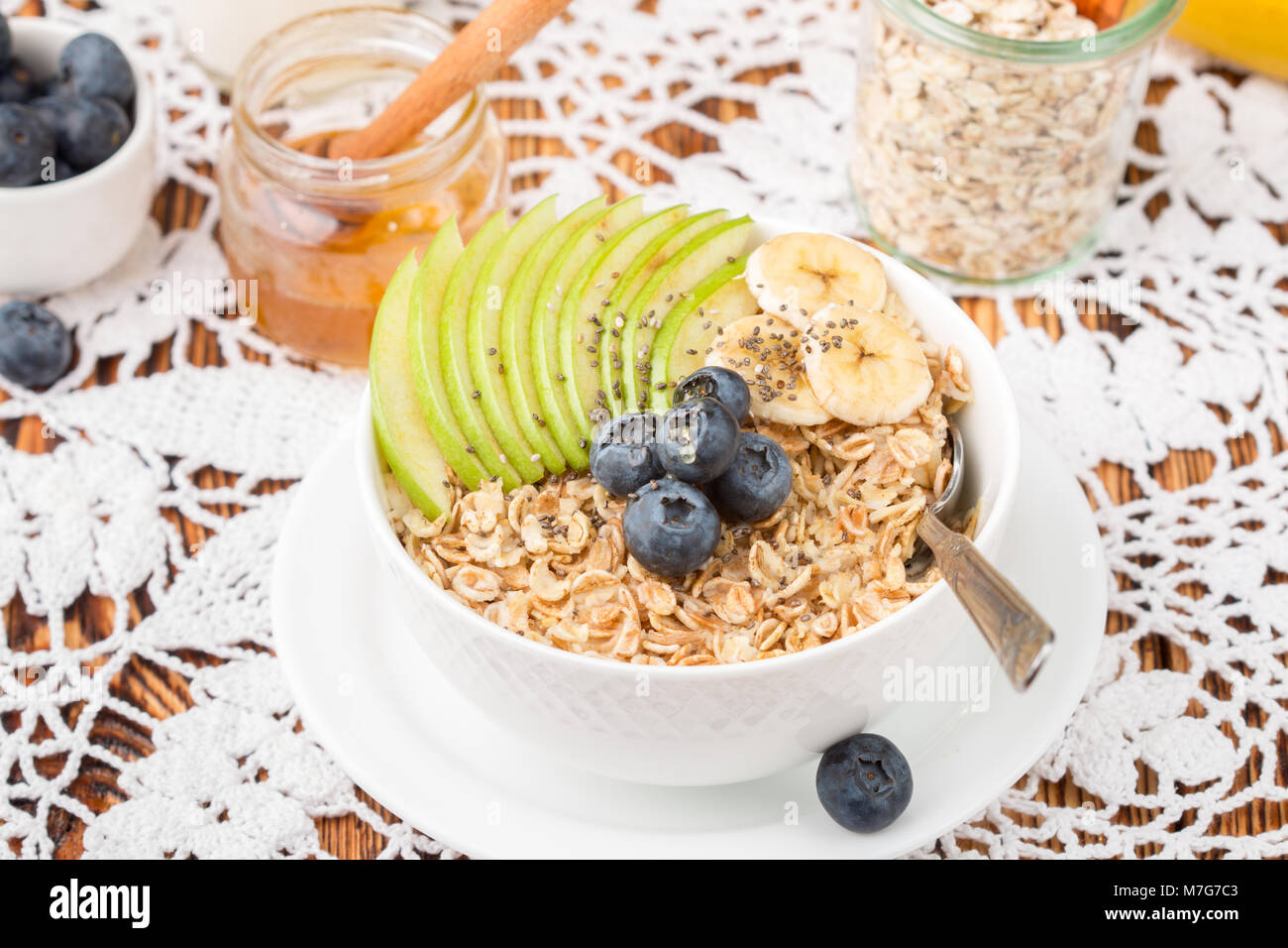 Farina di avena con mela verde, banana, mirtilli, miele e semi di Chia. Una sana prima colazione. Stile rustico. Messa a fuoco selettiva Foto Stock