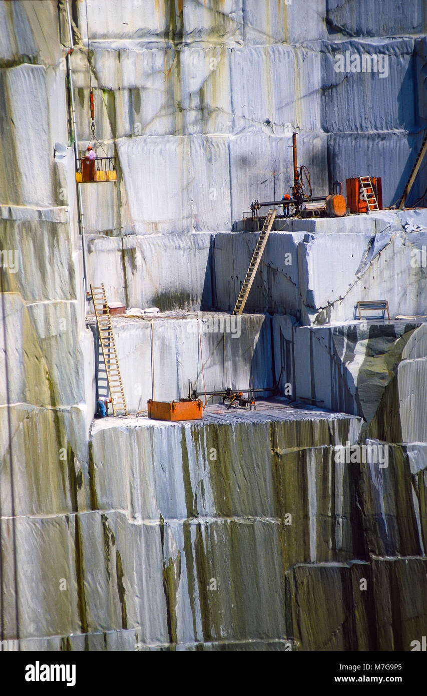 Operai sostare vicino al bordo di un ripido e caduta di pericolose in quanto il taglio dei blocchi di granito alla roccia di età cava in barre, Vermont, Stati Uniti, Foto Stock