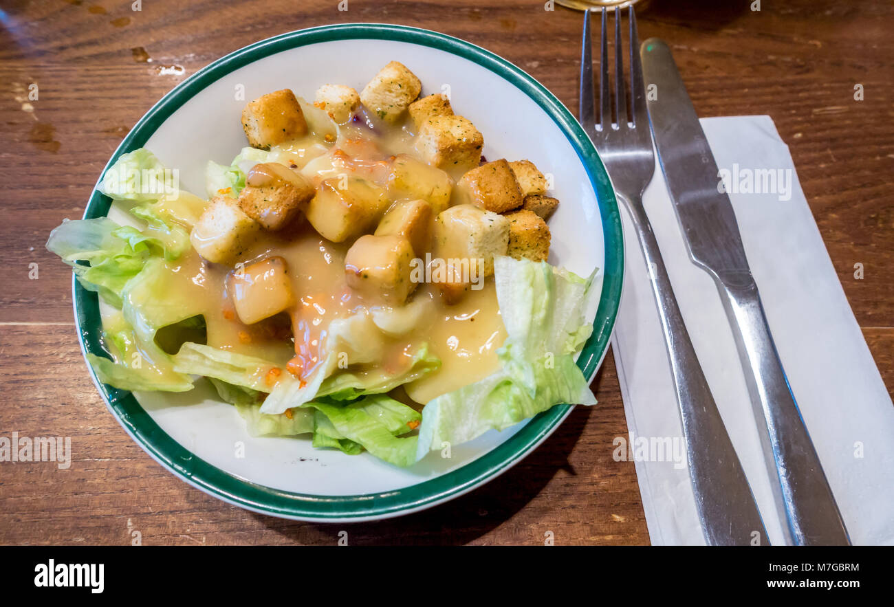 Una vista ravvicinata di un piatto di insalata con lattuga e crostini guarnita con un miele la salsa di senape. Foto Stock