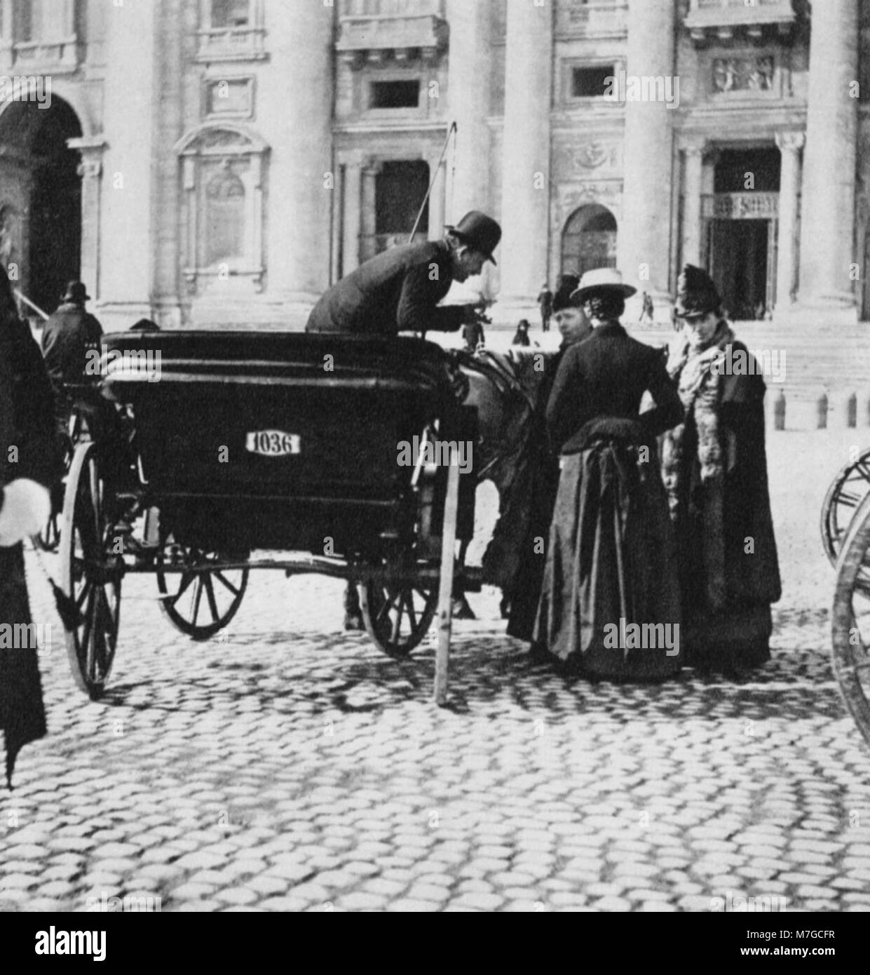 La fotografia di Giuseppe Primoli cattura una scena in Piazza San Pietro, città del Vaticano, con turisti e un cocchiere. Questa immagine dell'inizio del XX secolo offre uno sguardo sulla vita nel cuore di Roma. Foto Stock