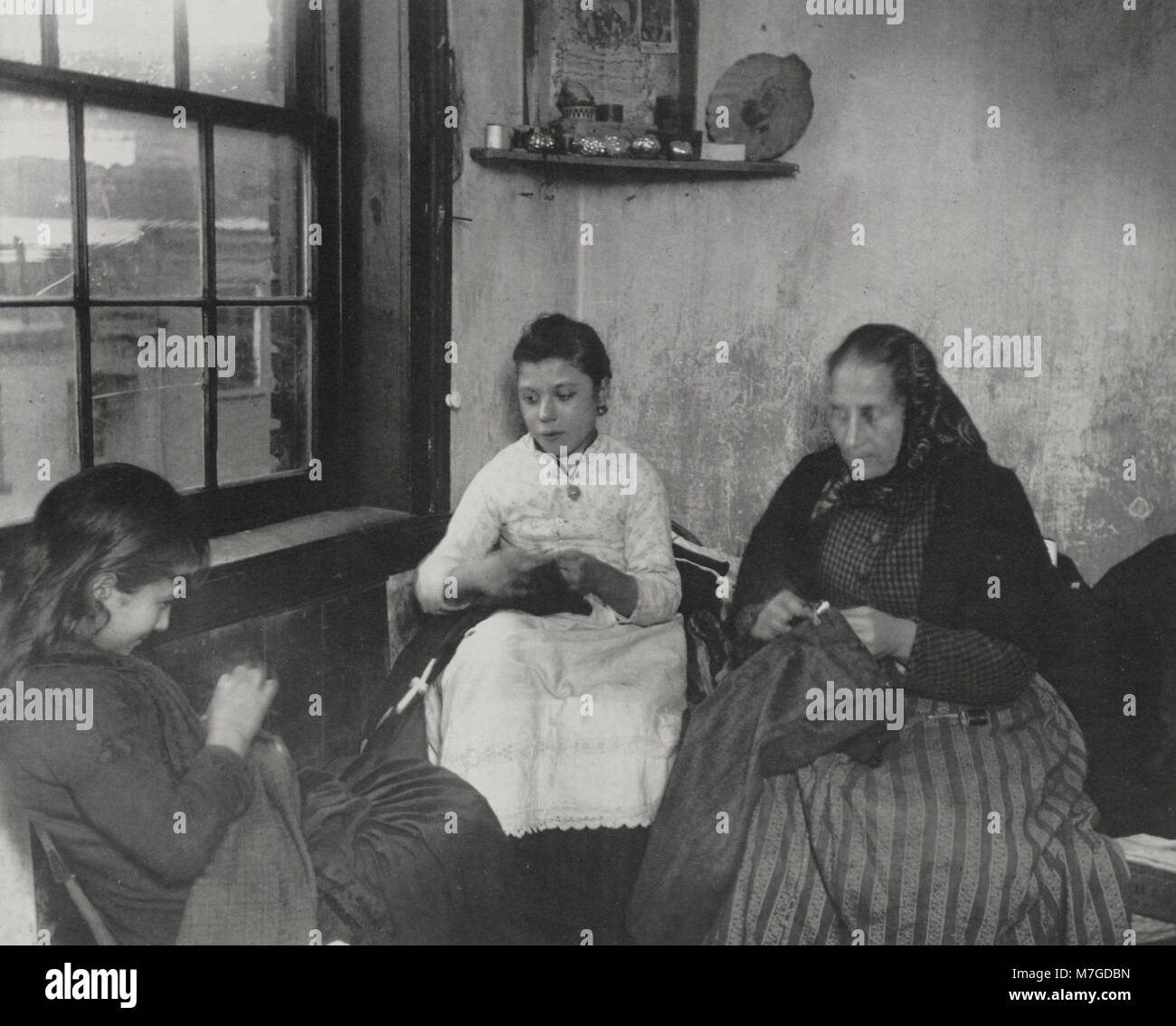 Una fotografia di Jacob A. Riis intitolata 'N,hen von Hosen f,r die Arbeiter' che raffigura una scena a Gotham Court, che mostra le condizioni di vita dei lavoratori nella New York all'inizio del XX secolo. Foto Stock