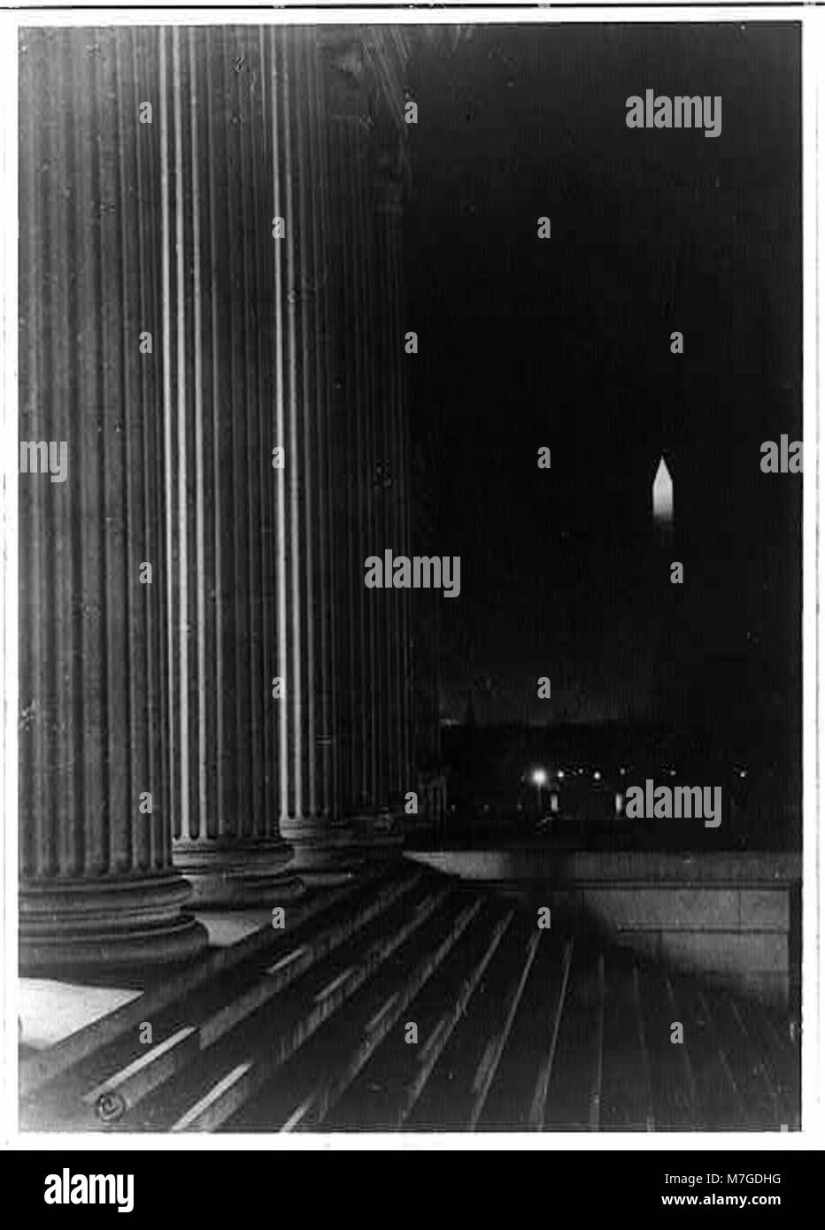 Questa vista notturna del monumento a Washington, D.C., offre un'immagine suggestiva dell'iconico monumento illuminato sullo sfondo del Tesoro degli Stati Uniti e della piscina riflettente. Foto Stock