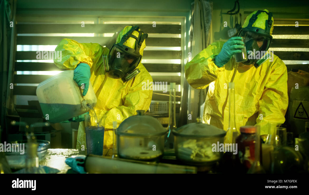 Nel farmaco sotterranea clandestina di laboratorio chimici indossare maschere protettive e tute Mix Prodotti Chimici per sintetizzare il nuovo lotto di farmaci. Foto Stock