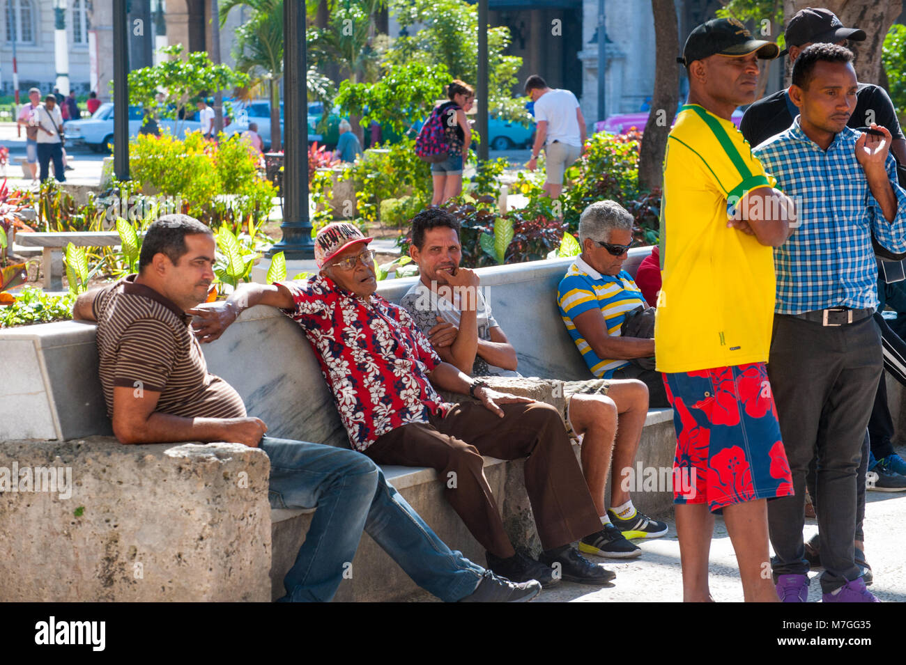 Un gruppo di uomini cubana il resto al Parque Central a l'Avana, Cuba Foto Stock