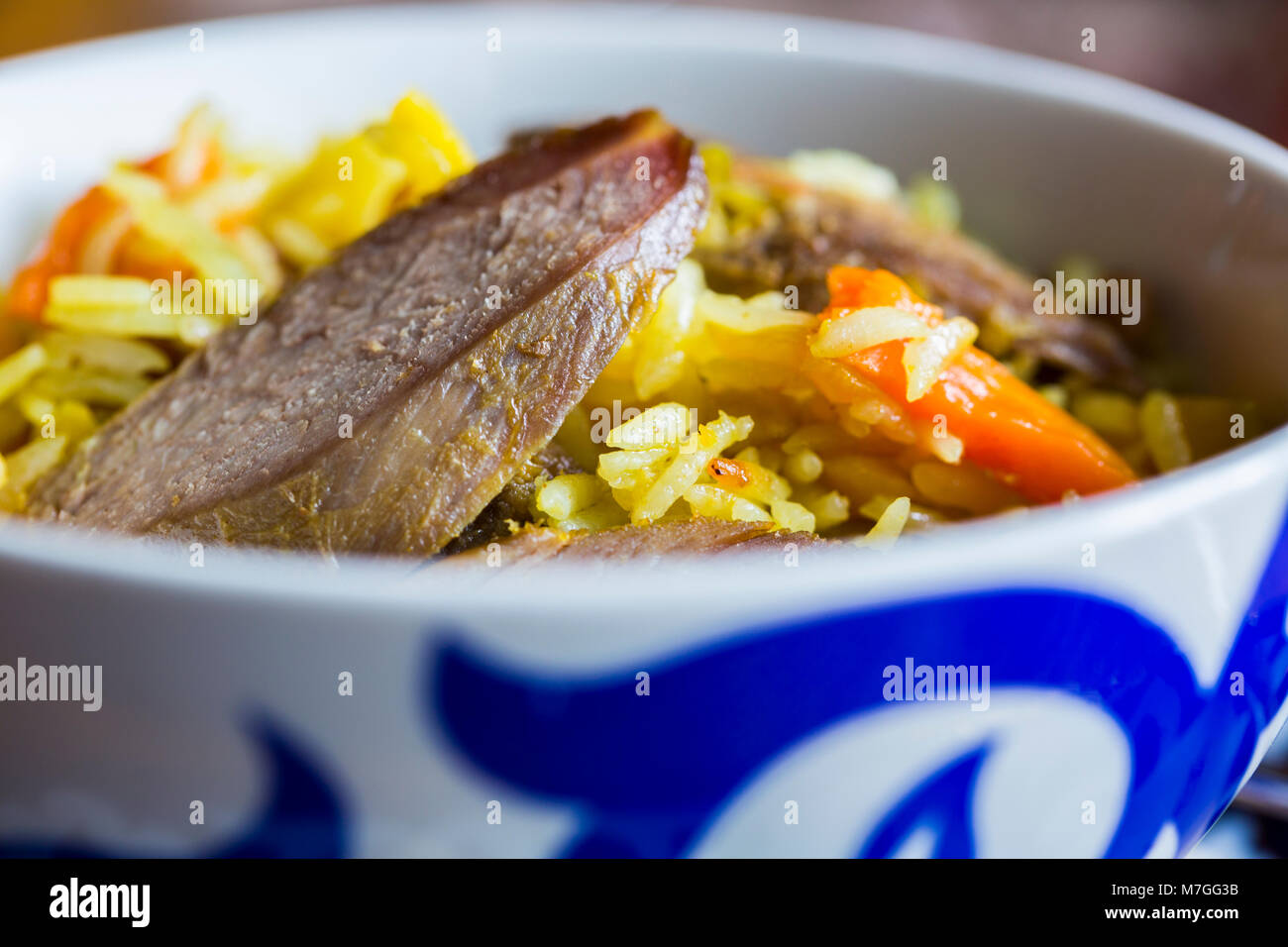 Piatto asiatico - Festive pilaf dal riso e carne bianca e le carote in una ciotola. perdere la vista Foto Stock