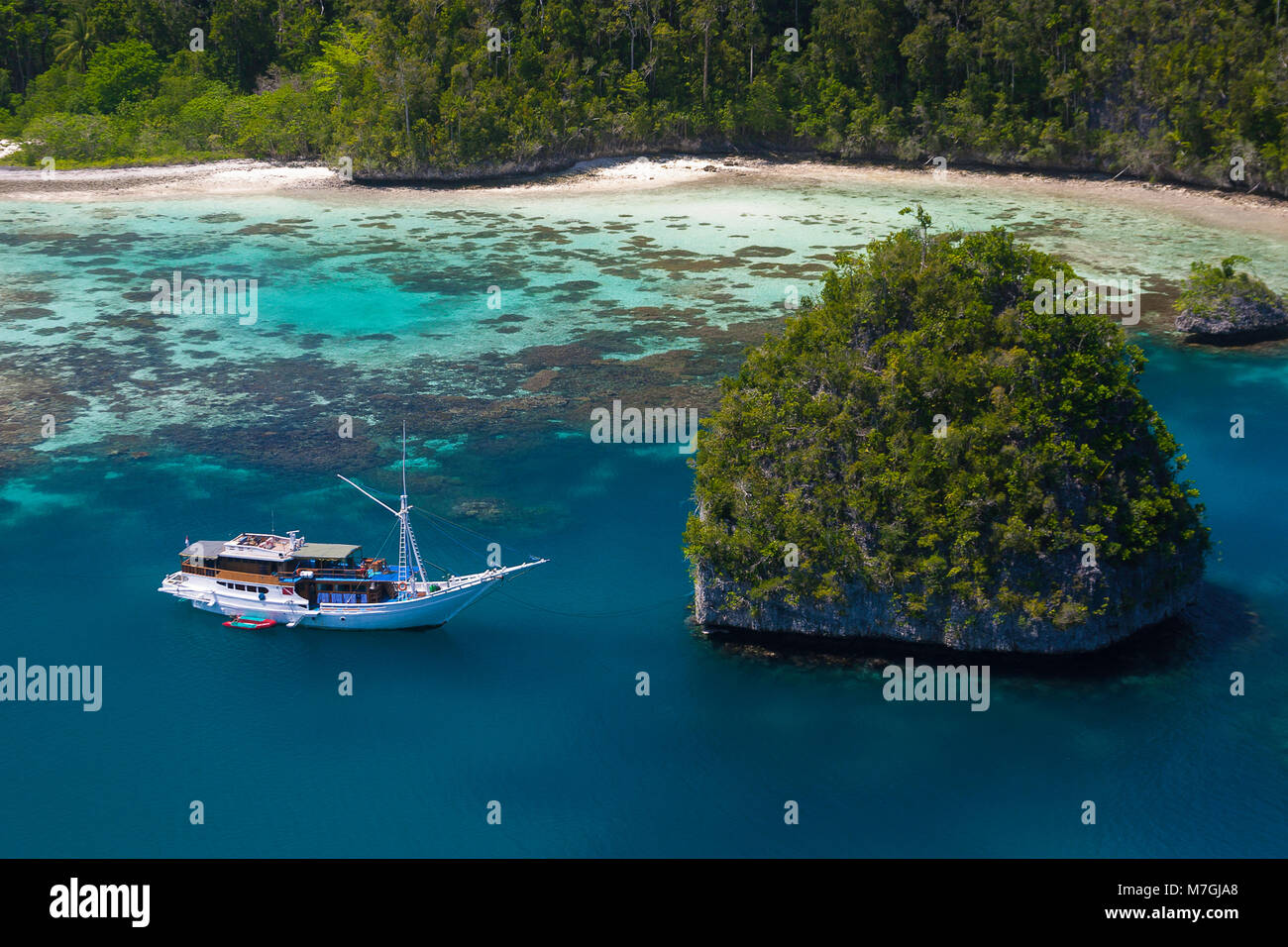 Una goletta di Bugis, live-a bordo della nave di immersione, al di ancoraggio in un isola di calcare laguna, Uranie Isola, Raja Ampat, Papua occidentale, in Indonesia. Foto Stock