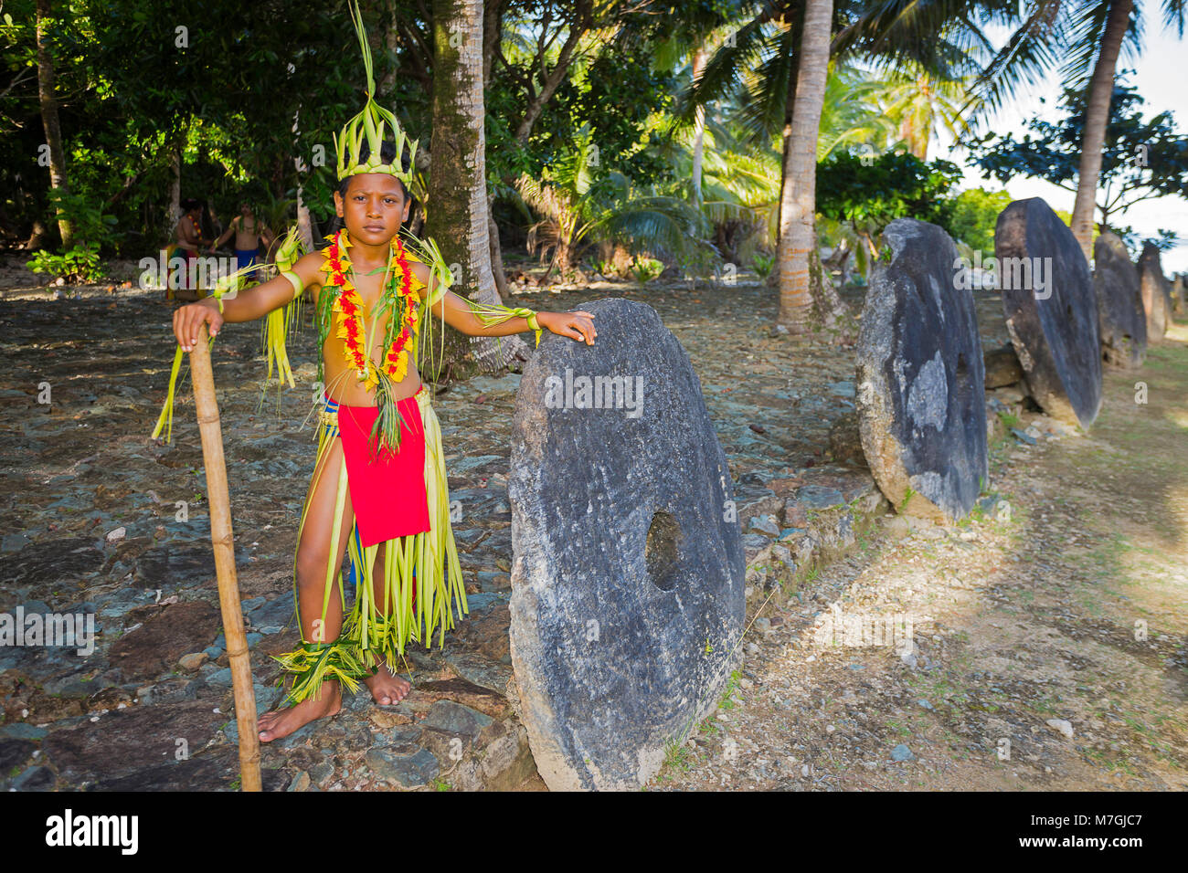 Questo ragazzo in un vestito tradizionale è raffigurato nella parte anteriore di una fila di pietra di denaro. Yap, Micronesia. Foto Stock
