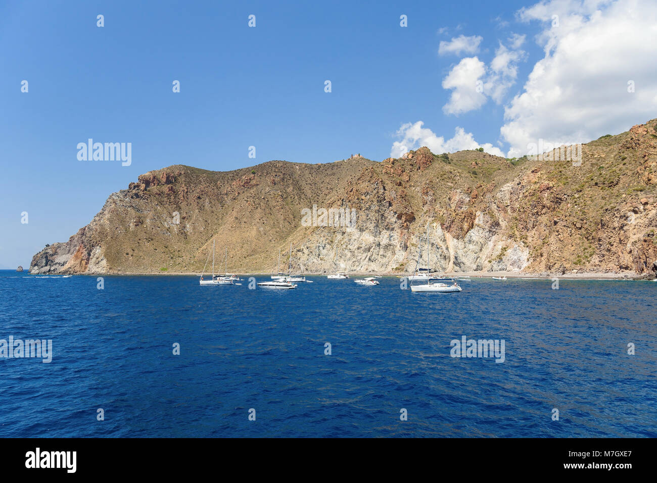 Yachts presso la costa rocciosa dell'isola di Lipari, Isole Eolie, Italia Foto Stock