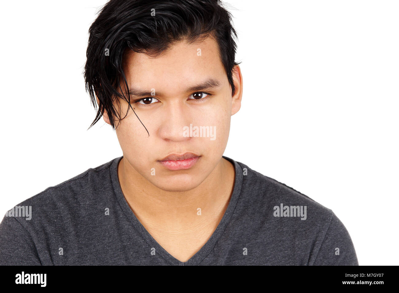 Ritratto di giovane uomo latino staring gravi su bianco Foto Stock