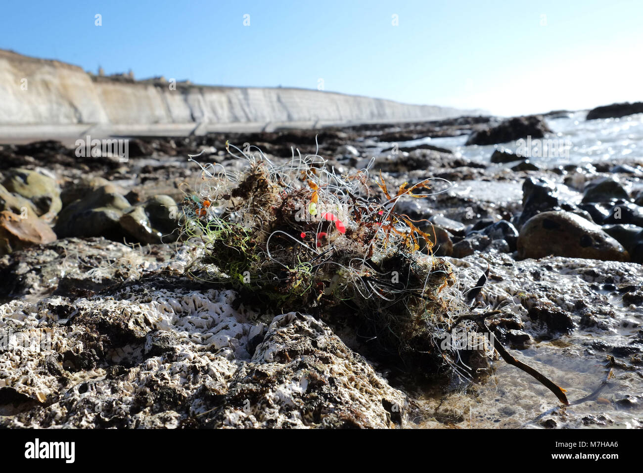 La lenza e pesi tra le rocce vicino a Brighton Marina. Spiaggia spazzatura si è incagliata Foto Stock