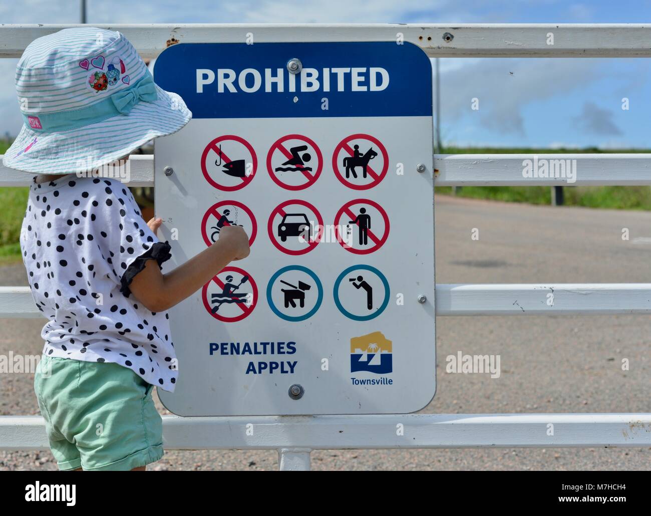 Bambino nello spiegare concetti su un segno vietate per proteggere l'alimentazione di acqua in Townsville, Ross diga sul fiume, Ross Dam Accesso, Kelso QLD, Australia Foto Stock