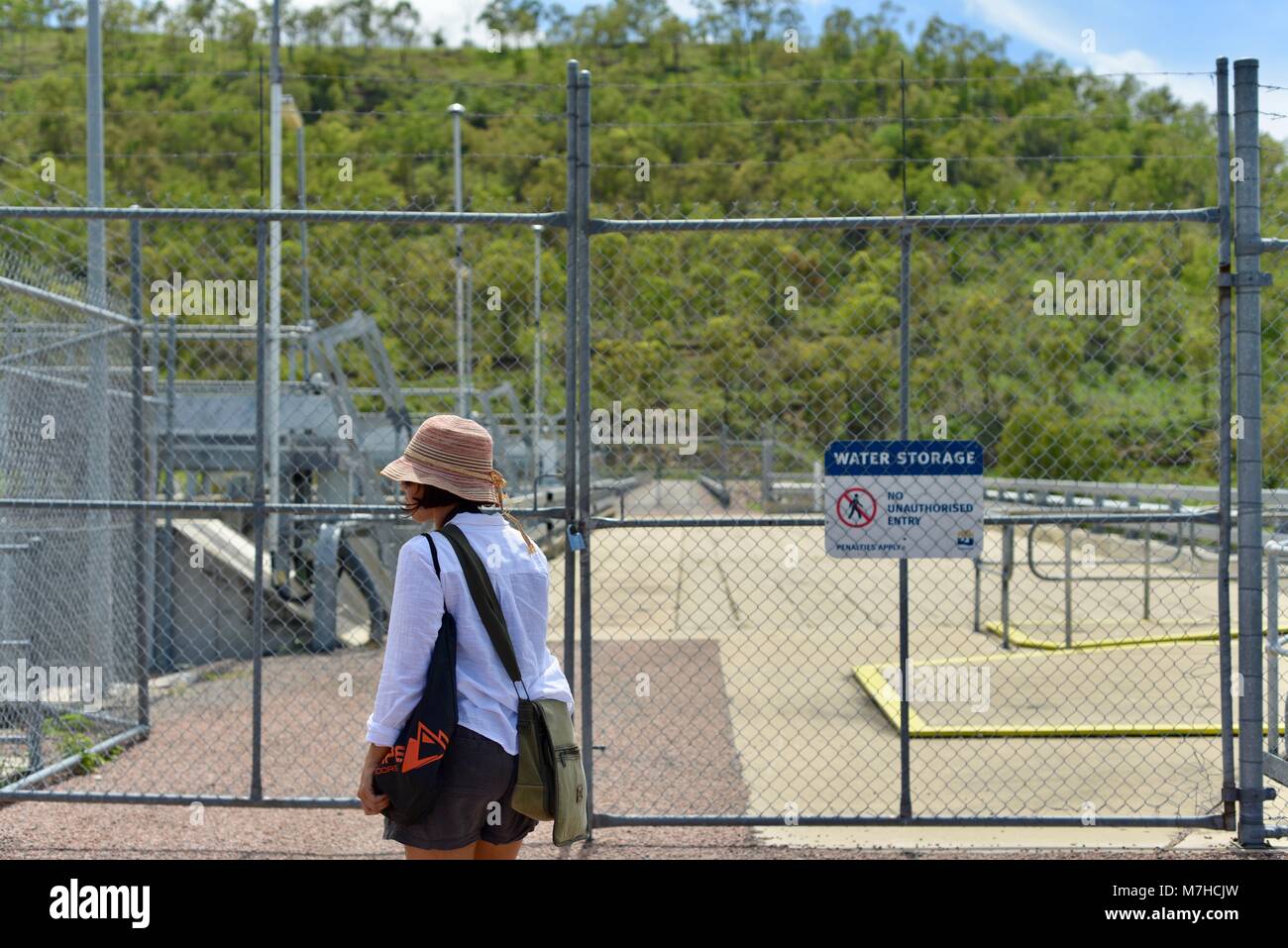 Membro del pubblico a piedi passato acqua deposito nessun ingresso non autorizzato le sanzioni si applicano firmato area, Ross diga sul fiume, Kelso QLD, Australia Foto Stock