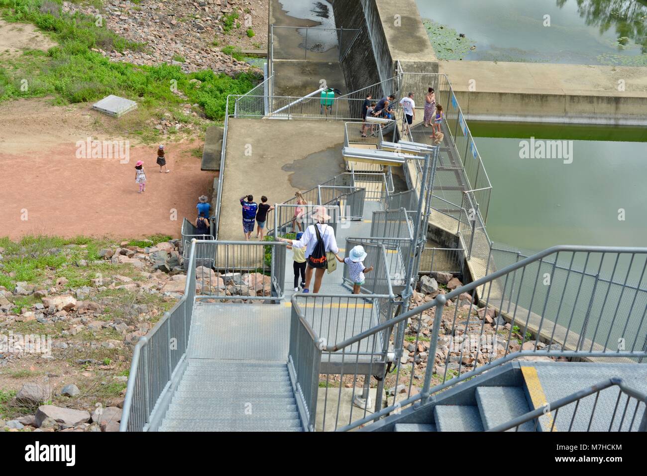 I bambini e gli adulti a piedi verso il basso in acciaio galvanizzato di scale, Ross diga sul fiume, Ross Dam Accesso, Kelso QLD, Australia Foto Stock