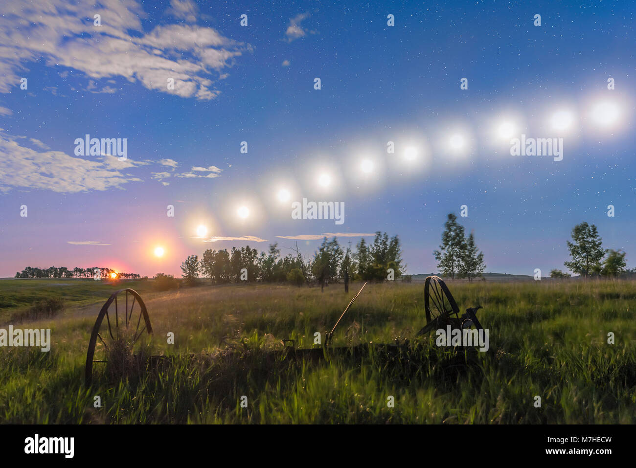 Sentiero del calante luna gibbous basso tracking attraverso il cielo in Alberta, Canada. Foto Stock