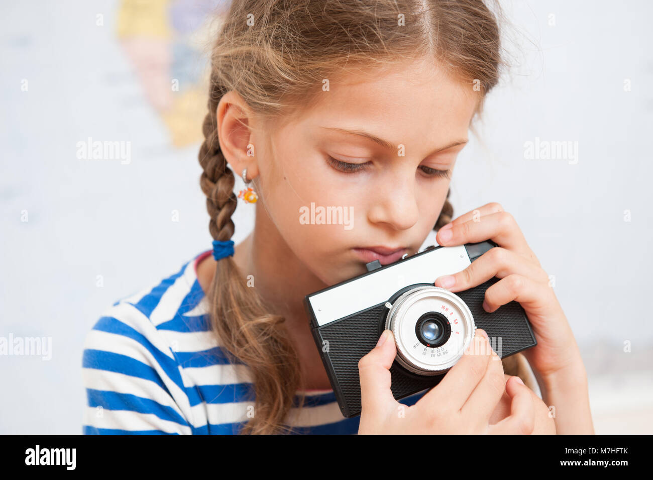 Ritratto di carino bambina tenendo un vintage fotocamera a pellicola Foto Stock