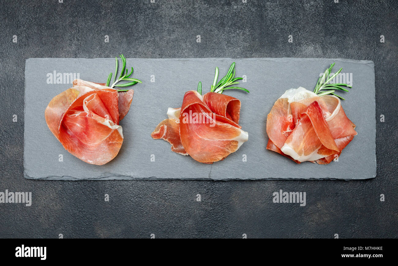 Italian prosciutto crudo o spagnolo jamon. Il prosciutto crudo su pietra tagliere Foto Stock