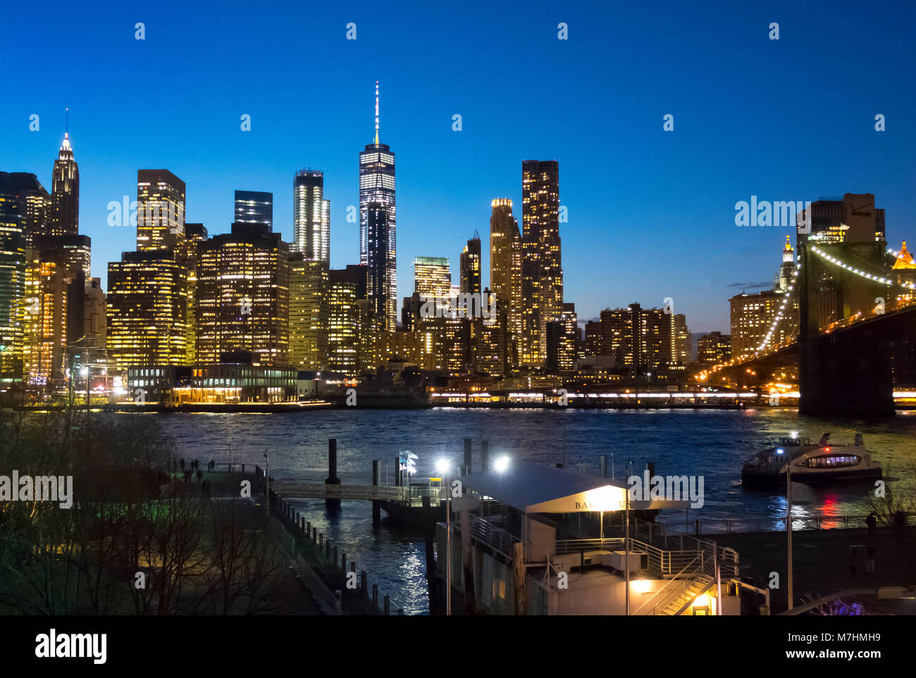 La parte inferiore di Manhattan skyline è visto da Brooklyn di notte in tutta l'East River Foto Stock