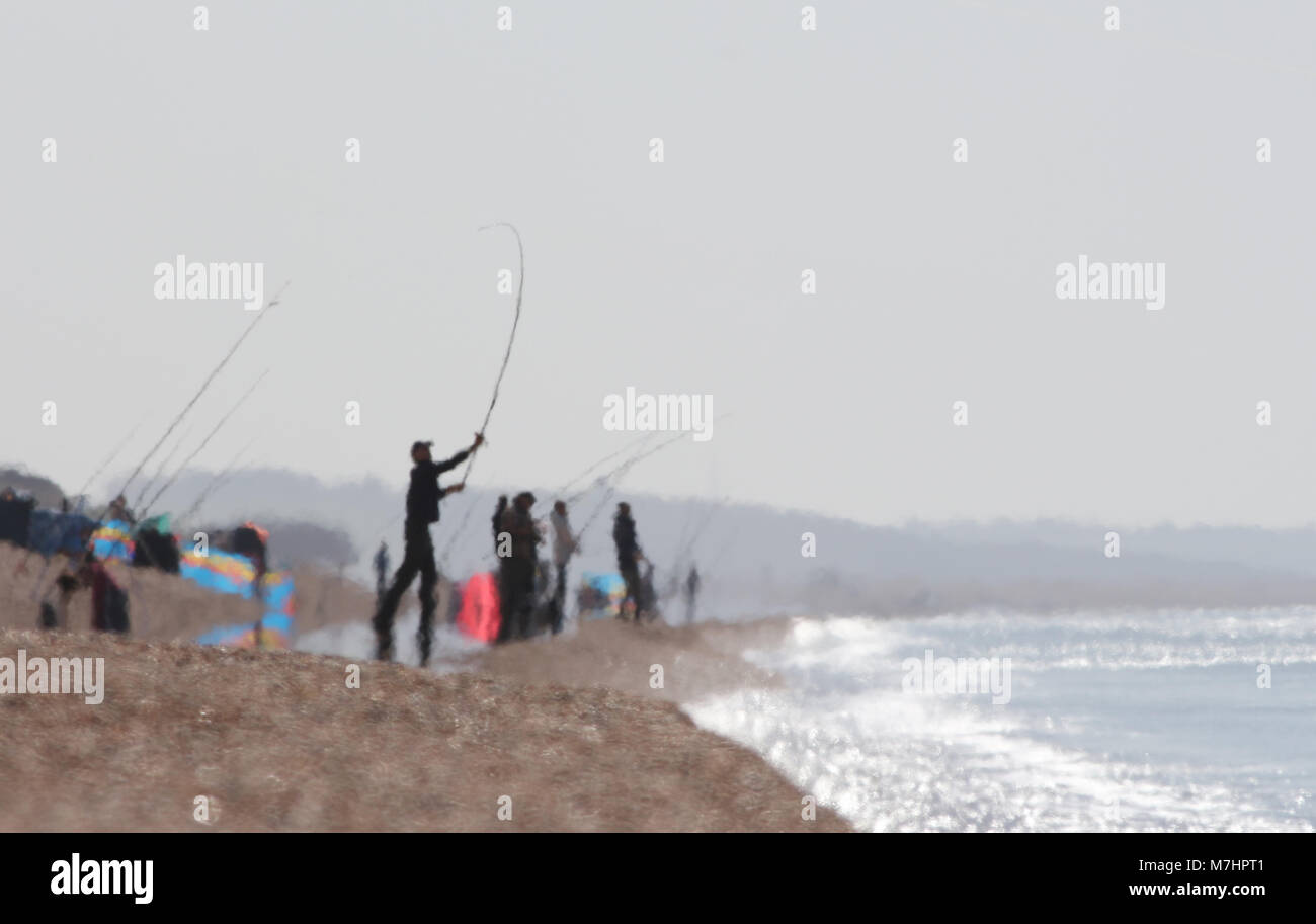 I pescatori in un Haze di calore su un bruciante giorno su Chesil Beach UK, principalmente per la pesca dello sgombro Foto Stock