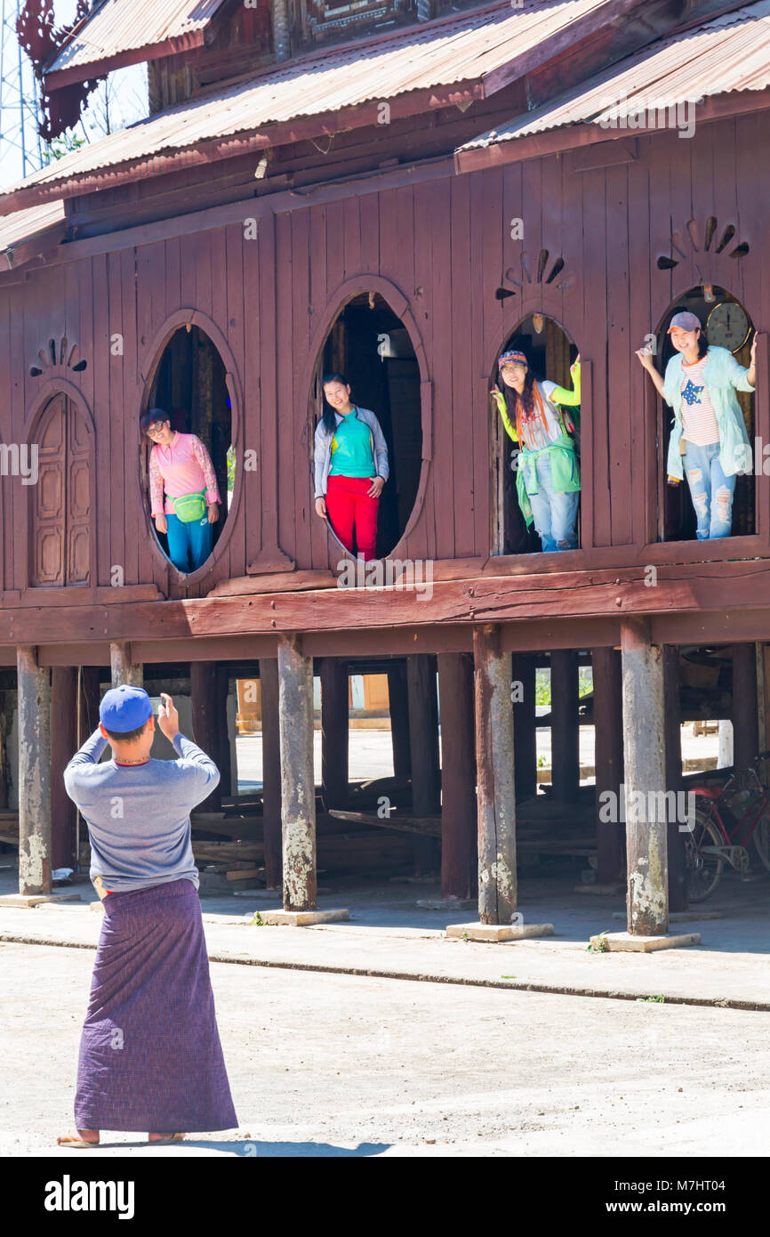 I turisti che posano per una foto a finestre ovali di Shwe Yan Pyay legno teak monastero Shwe Yaunghwe Monastero, Nyaungshwe, Lago Inle, Myanmar (Birmania), Asia Foto Stock