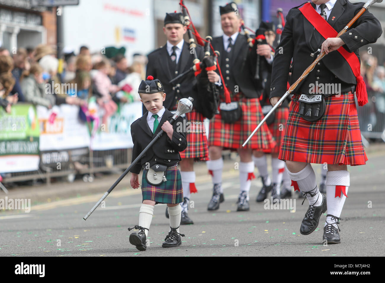 Birmingham's Irish comunità celebra il giorno di San Patrizio con la loro annuale sfilano per le vie della città. Un giovane ragazzo conduce la Irish band di tubazioni in parata. Foto Stock