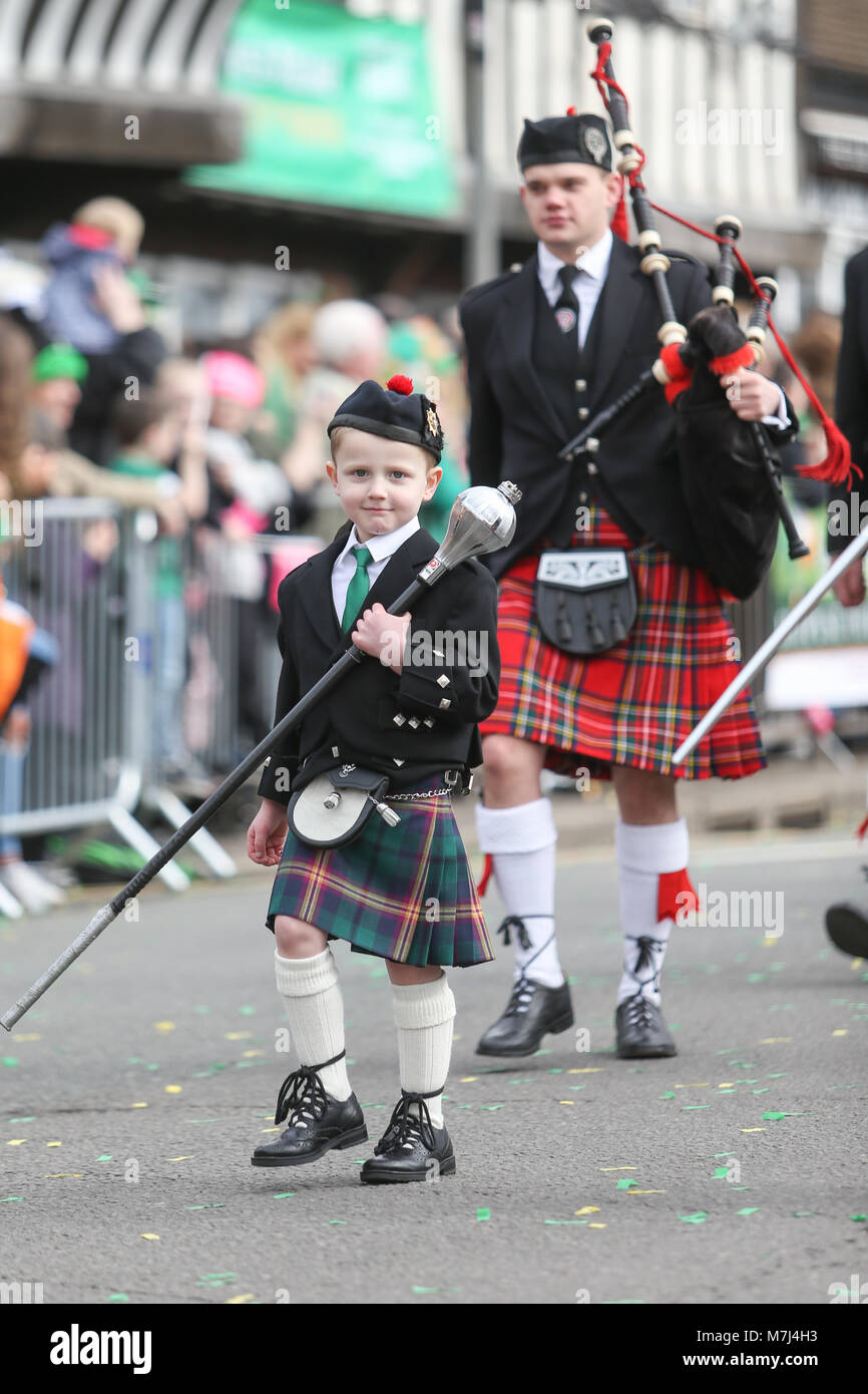 Birmingham's Irish comunità celebra il giorno di San Patrizio con la loro annuale sfilano per le vie della città. Un giovane ragazzo conduce la Irish band di tubazioni in parata. Foto Stock