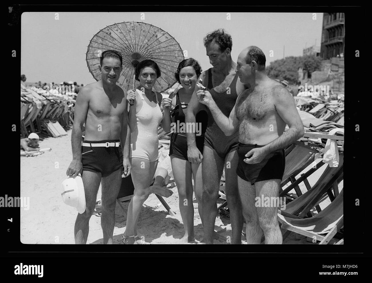 Una foto ravvicinata di una spiaggia affollata a Tel Aviv, che mostra numerosi naviganti che si godono il clima caldo e le viste costiere. L'immagine cattura la vibrante atmosfera della spiaggia, mostrando Tel Aviv come una popolare destinazione turistica. Foto Stock