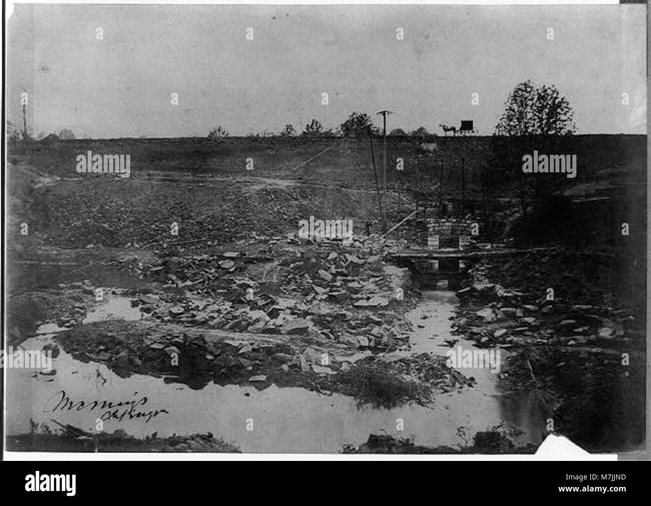 Una fotografia storica che mostra un cavallo e una carrozza su una collina, che si affaccia su un letto del fiume, catturando un momento di vita rurale e di trasporto di un periodo precedente. Foto Stock