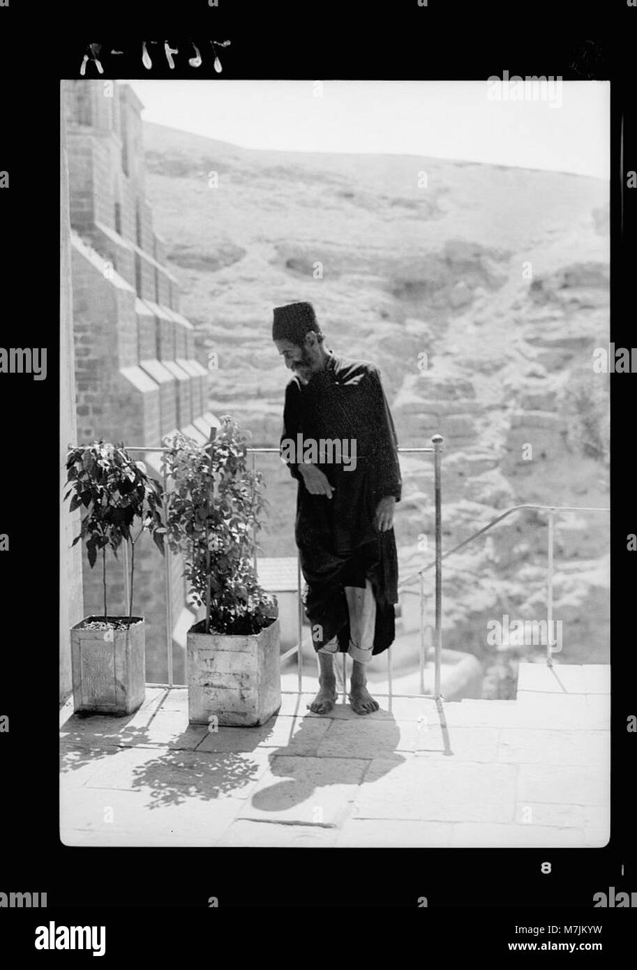 Questa immagine raffigura un monaco anziano al monastero di Mar Saba, situato nel deserto della Giudea. Il monastero, un importante sito cristiano, è noto per la sua architettura bizantina storica e la sua posizione remota. L'immagine riflette la pacifica vita monastica dei monaci ortodossi in questo santuario spirituale. Foto Stock