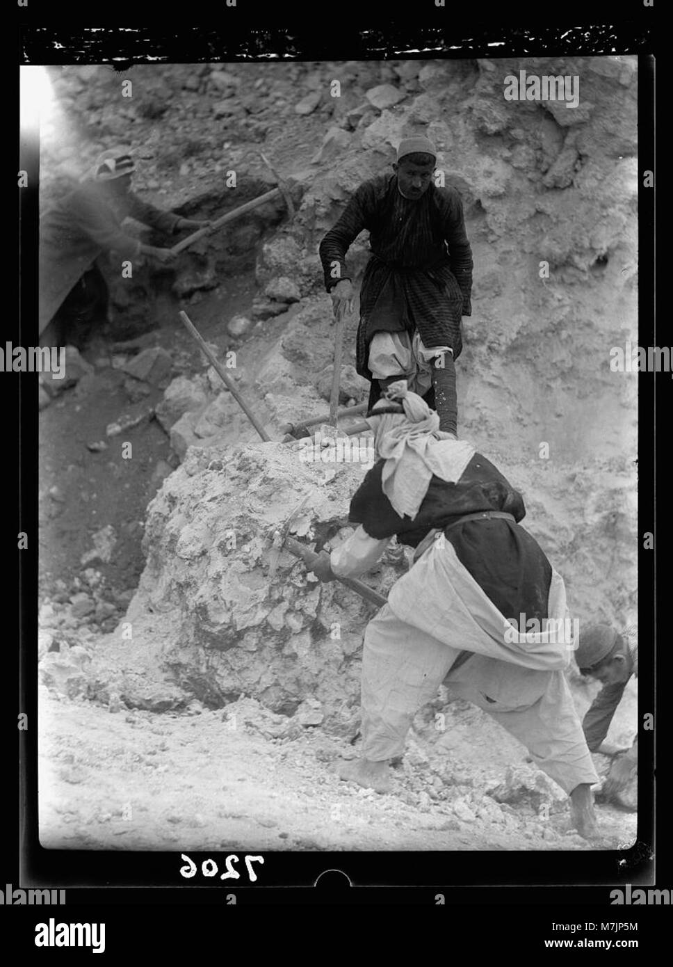 Gli scavi a Tel Deweir, vicino a Lachish, rivelano che gli uomini stanno ripulendo i detriti da un incendio. Manufatti, tra cui teste di lancia di ferro, punte di freccia e frammenti di armature in scala, sono stati trovati, indicando un attacco del 588 a.C. Foto Stock