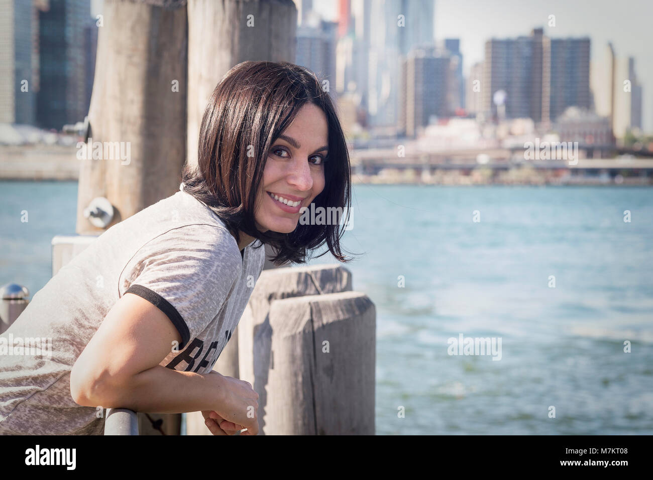 Una donna appendere fuori su un molo di Brooklyn in Dumbo. Foto Stock