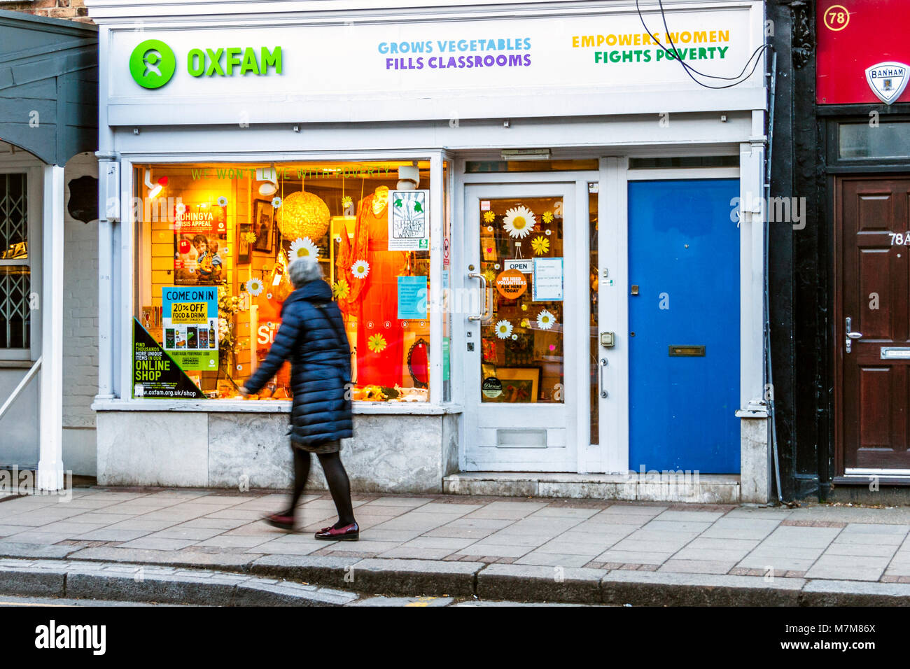 Un passaggio pedonale in cerca della finestra della carità di Oxfam shop nel villaggio di Highgate, London, Regno Unito Foto Stock