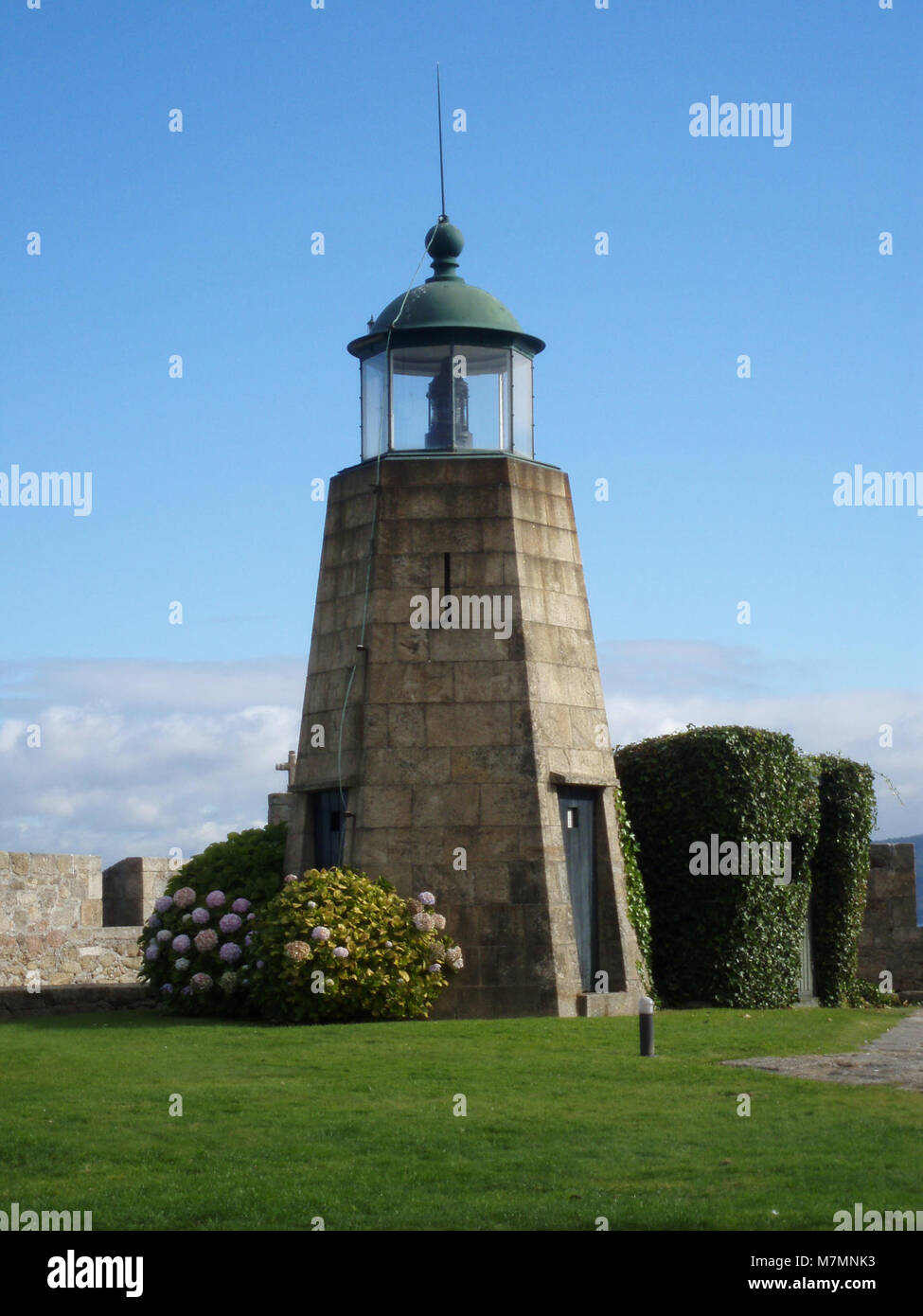 Il Castillo de San Antón è una storica fortezza costiera in Spagna costruita per la difesa e successivamente dotata di un faro, che sottolinea il suo ruolo nella navigazione marittima e nella protezione. Foto Stock