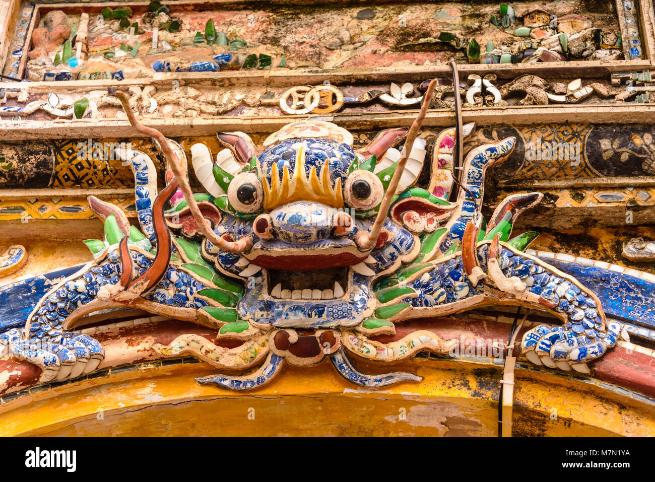 Un ornato di ceramica cinese mosaici di Lion al di sopra di un arco in Hoàng thành (Città Imperiale) una cittadella fortificata costruita nel 1804 in tinta, Vietnam. Foto Stock