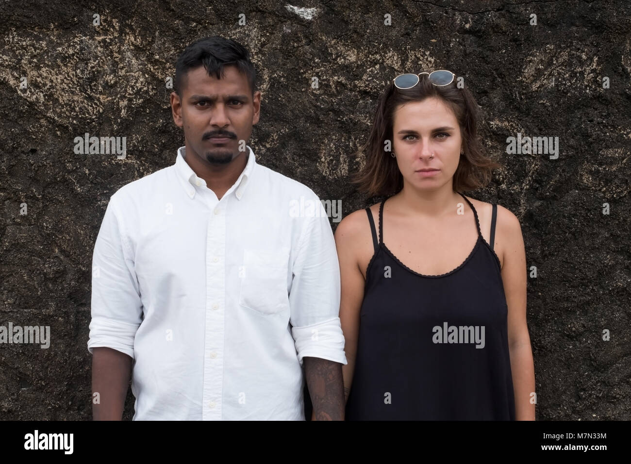 Emotional Ritratto di giovane appena una coppia sposata. Si trovano vicino alla parete e guardare su telecamera Foto Stock