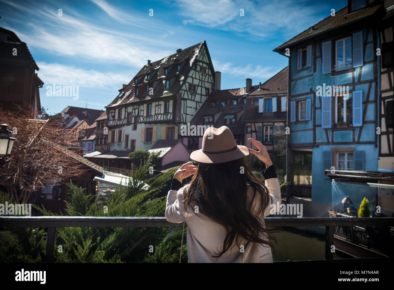 Irriconoscibile la giovane donna in piedi indietro sul lungomare della città e con una bellissima vista e ispirato. Elegante turista femminile esplorare la città vecchia in giornata soleggiata Foto Stock